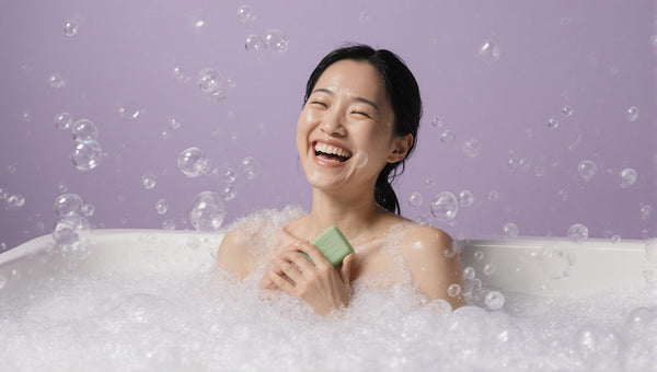 happy laughing woman in the bath holding a soap